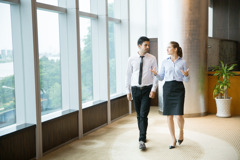Two,Business,People,Walking,In,Office,And,Talking,To,Each