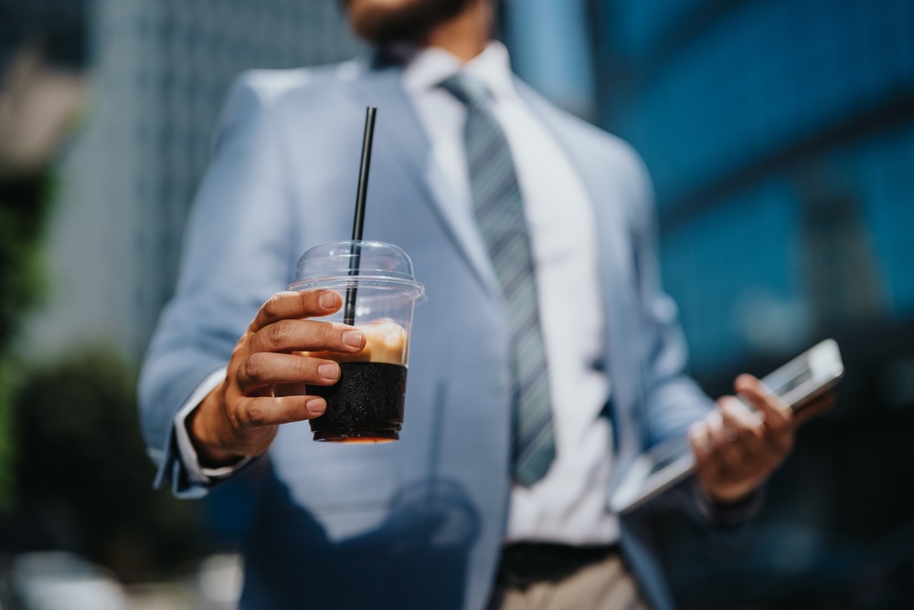 A,Businessman,In,A,Suit,Holds,An,Iced,Coffee,Cup